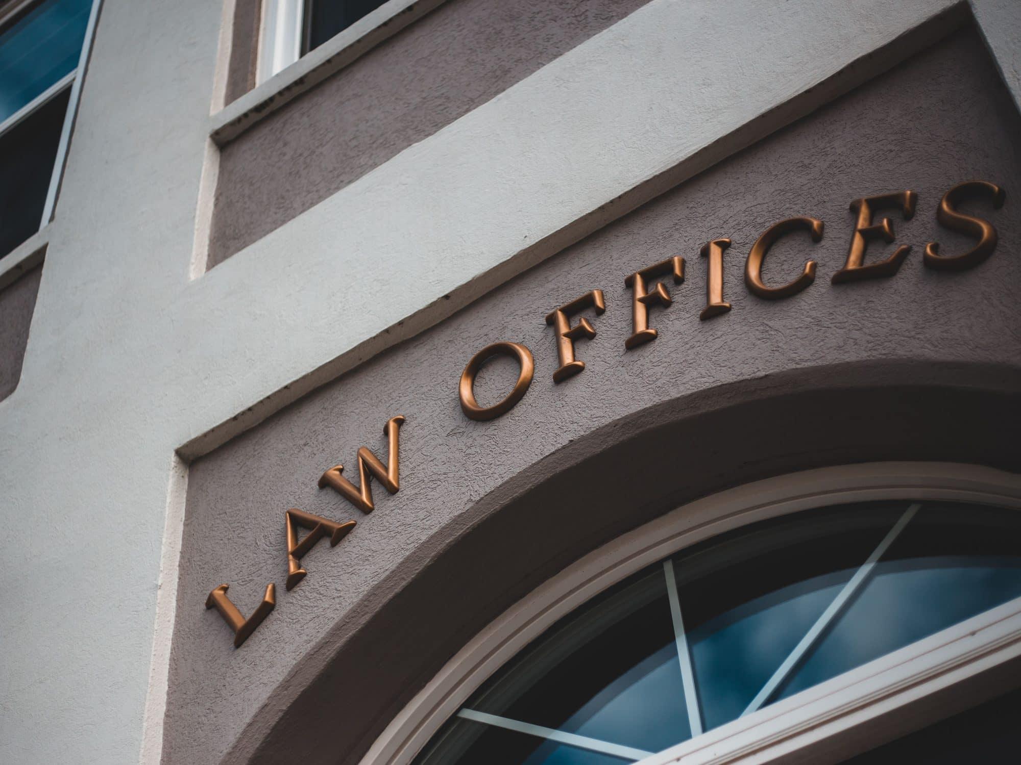 Brass lettering reading LAW OFFICES on a building facade